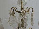 a crystal chandelier with a candle holder and two candles