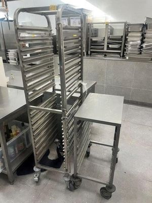 many trays of food sitting on a cart in the kitchen