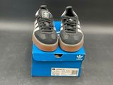 adidas superstar shoes in a box on a grey surface
