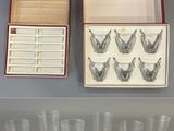 six verres et une boîte de verres vides posés sur une table