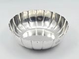 a silver bowl on a white surface with a white background