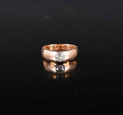 un gros plan d'une bague en or sertie d'un diamant sur un fond noir