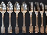 a lot of spoons and forks on the table