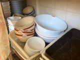 many plates and bowls stacked on a shelf in the kitchen