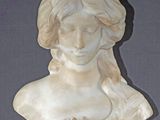 marble bust of a woman with long hair and a flower in her hair