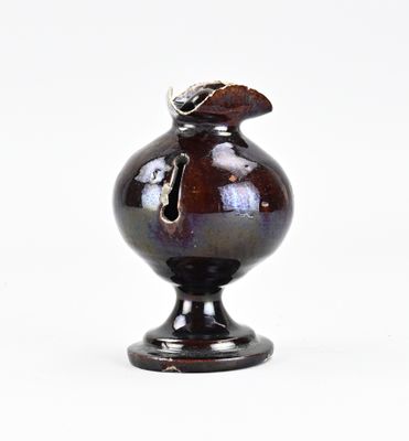 un vase noir orné d'un oiseau sur un fond blanc