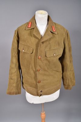 une veste marron posée sur un mannequin, sur fond gris