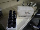 a box of black bottles sitting on a counter next to a box of black bottles