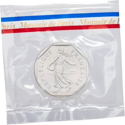 un gros plan d'une pièce de monnaie dans un sachet en plastique sur fond blanc