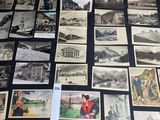 plusieurs vieilles cartes postales et photos de personnes et de bâtiments posées sur une table
