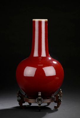red vase on stand against a black background with a black background