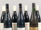 six bottles of wine are lined up in a row on a table
