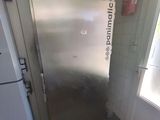 a stainless steel refrigerator in a kitchen with a window