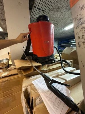 une personne tenant un seau rouge au sommet d'une pile de cartons