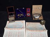 two open books on a table with a watch and other items