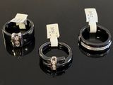 trois anneaux munis d'étiquettes, posés sur une surface noire
