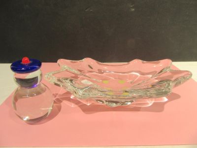 a glass bowl and a bottle of water on a table