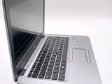 a silver laptop with a black keyboard on a white surface