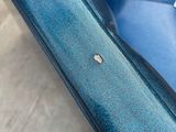 someone standing next to a blue couch with a small bug on it