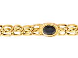 Gros plan sur un bracelet en or orné de pierres bleues