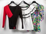 three women ' s shirts hanging on a clothes rack in a closet