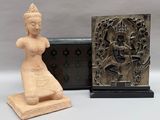 statue d'une femme tenant un vase à côté d'une plaque en bois