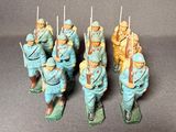 several figurines of men in blue uniforms are lined up on a gray surface