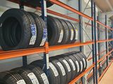 tires are stacked on shelves in a warehouse with orange shelvings