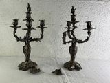 two metal candelabs that are sitting on a table