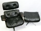 un fauteuil et un repose-pieds en cuir noir sur fond blanc
