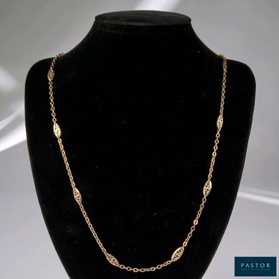 un collier à chaîne en or présenté sur un mannequin, sur fond blanc