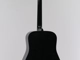 an acoustic guitar hanging on a wall in a white room