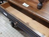 a wooden table with a drawer underneath it in a store