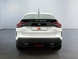 the rear end of a white car in a white room