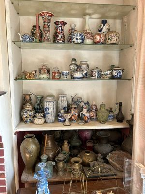 many vases on the shelves in the corner of the room