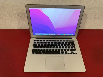 an apple macbook air laptop computer sitting on top of a red table