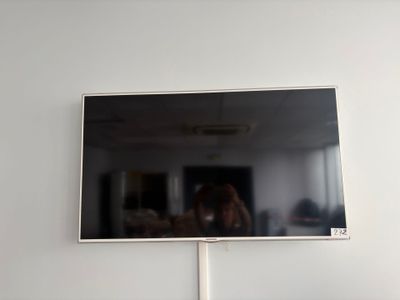 someone is taking a picture of their reflection in the mirror of a flat screen tv