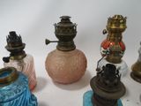 many different colored glass vases on a white surface