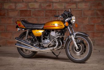 a yellow motorcycle parked in front of a brick wall