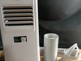 un petit climatiseur posé sur une table à côté d'une tasse de café