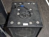 un ampli noir posé par terre à côté d'une enceinte
