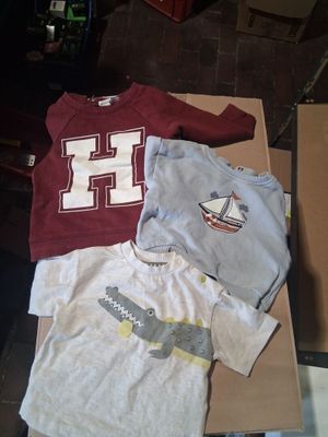 three shirts that are sitting on top of a cardboard box