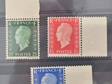 quatre timbres différents exposés dans une vitrine posée sur une table