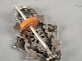 a small metal object with a orange button on it