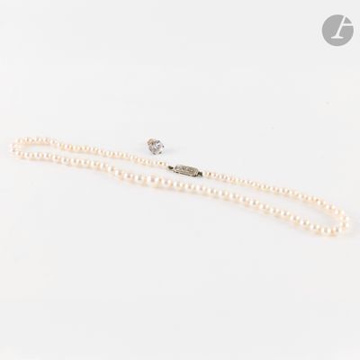 un collier de perles blanches avec un fermoir en diamant, sur fond blanc
