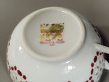 a white cup with a red and yellow design on it