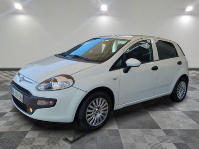 la petite voiture blanche est garée sur un sol en damier