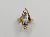 une bague en or sertie d'une topaze bleue au centre