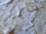 many white handkerchiefs on a table with a vase of flowers