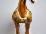a figurine of a horse on a wooden stand